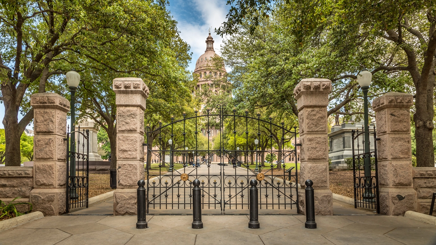 Front gate of the Texas capitol and its surrounding trees. 
