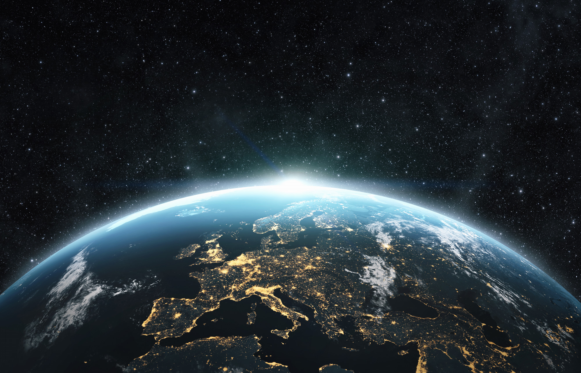 A satellite view of the Earth with a focus on Europe and the sun rising over the horizon.
