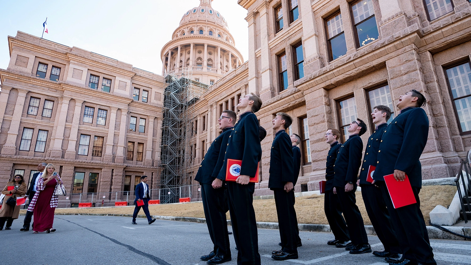 A group of A&M singing cadets singing in front of the Texas capitol building.